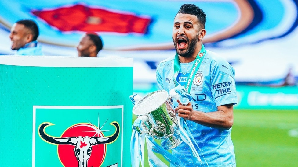FULL OF GLEE : Mahrez spends a moment with the Carabao Cup following City’s success in April 2021.