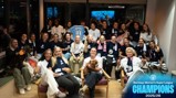 Group photo of Manchester City Women's team celebrating winning the Barclays Women's Super League 2025/26. The team is gathered in a room, some holding dogs, Manchester City scarves, and a jersey. Text signifies their championship