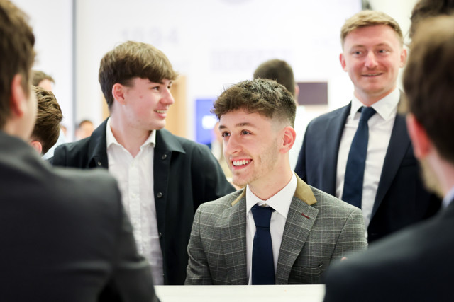Group of men at a business meeting wearing suits. Faces are blurred.