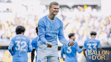 A soccer player in a Manchester City jersey celebrates on the field. Teammates surround him with the 'Ballon D'Or 2026' text overlay.