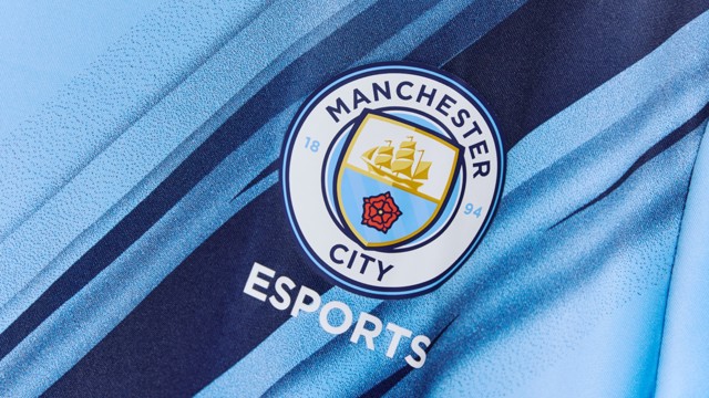 Image of the Manchester City Esports logo. The logo features the Manchester City crest with the word 'Esports' below it on a light blue and dark blue gradient background.