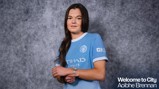A woman wearing a Manchester City jersey stands against a gray background, with text reading 'Welcome to City Aoibhe Brennan.'