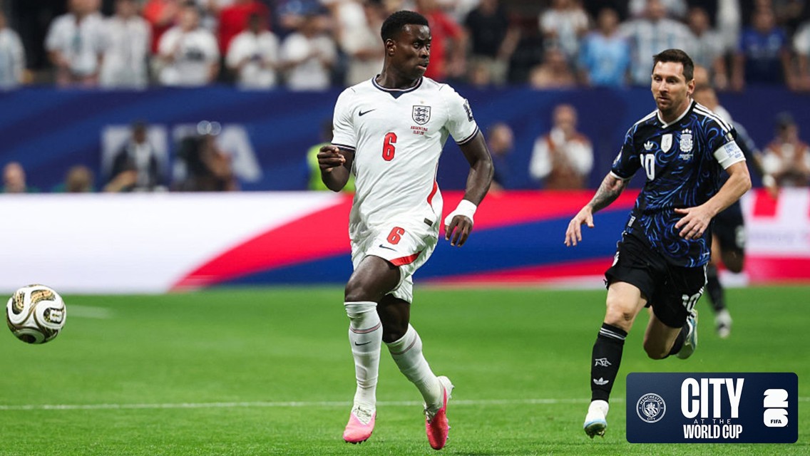 Soccer players from England and Argentina in action during a match at the World Cup. The match is played on a green pitch with stadium and crowd in the background.