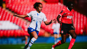 Two women soccer players in motion. One in a white Manchester City kit and the other in a red Charlton Athletic kit. They are playing in a stadium with red seats.