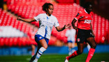 Two women soccer players in motion. One in a white Manchester City kit and the other in a red Charlton Athletic kit. They are playing in a stadium with red seats.