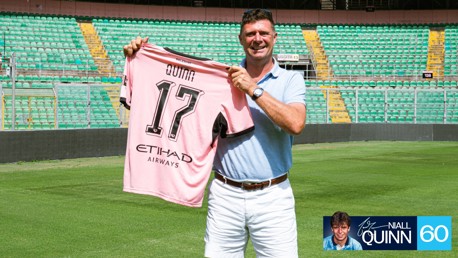 A person holding a Palermo soccer jersey with the name 'Quinn' and number '17'. The setting is an empty stadium with green seats. A small digital image of Niall Quinn is in the corner.