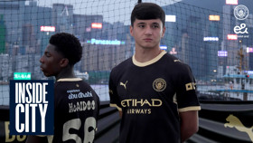 Two men in Manchester City jerseys stand outdoors with a cityscape in the background, marked with 'Inside City.'