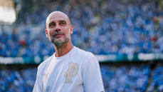 A person wearing a white Puma shirt with a 'P' logo stands in front of a blurry crowd in a stadium setting.