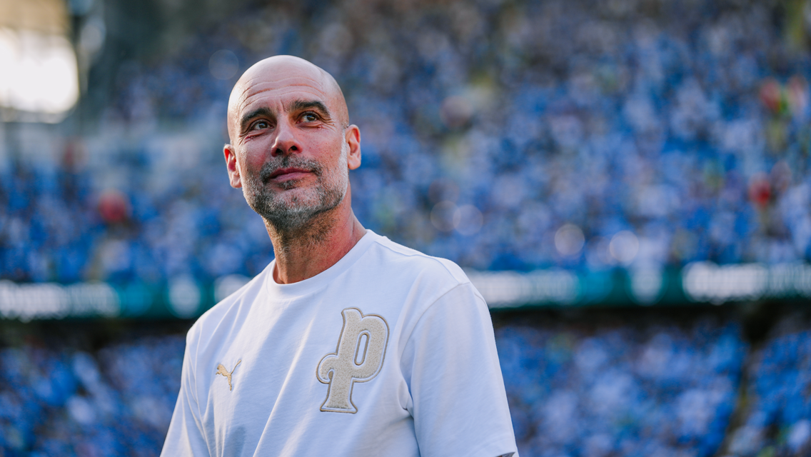 A person wearing a white Puma shirt with a 'P' logo stands in front of a blurry crowd in a stadium setting.
