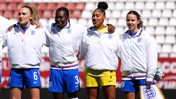 Group of female soccer players in England gear with numbers 6 and 3 visible, standing in a stadium.