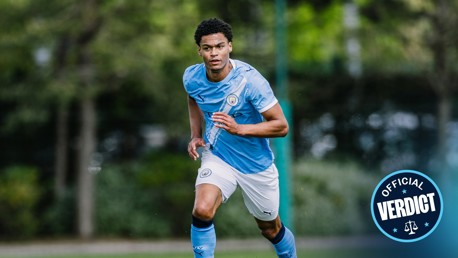 Blurred image of a soccer player in a Manchester City uniform in action on the field, with 'Official Verdict' badge in the corner.