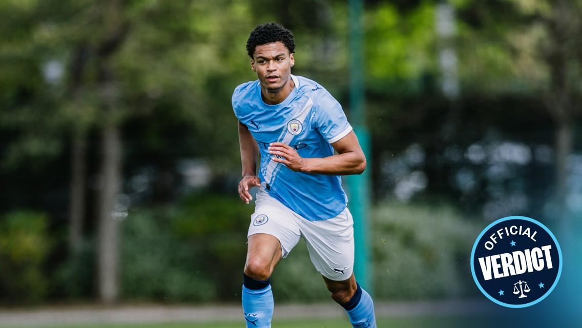Blurred image of a soccer player in a Manchester City uniform in action on the field, with 'Official Verdict' badge in the corner.