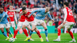 Players from Arsenal and Manchester City in action during a football match, competing for ball possession.