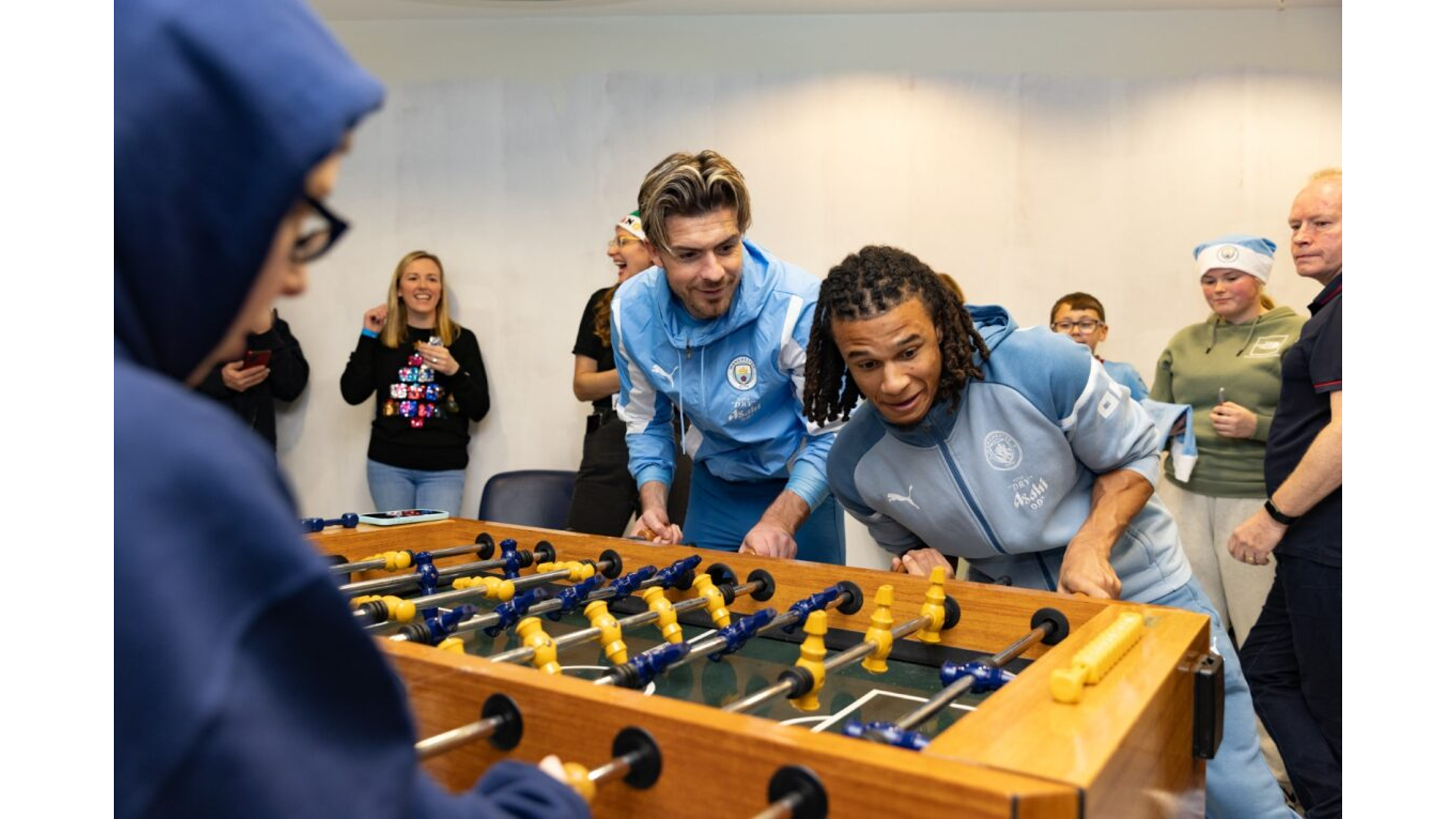 TABLE TOPPERS: Jack Grealish and Nathan Ake play table football with some of the young patients.