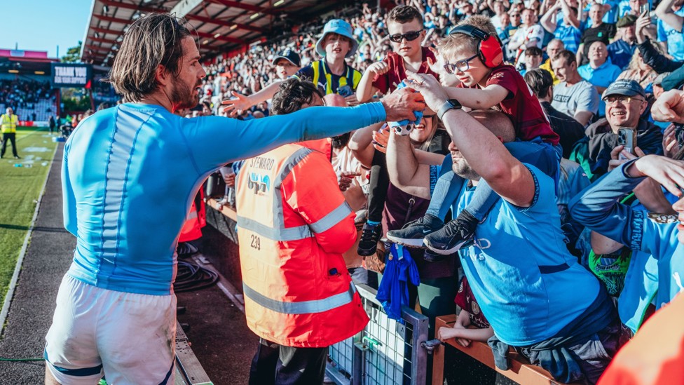 A MOMENT TO TREASURE : Jack Grealish gifts his match shirt to a young fan.