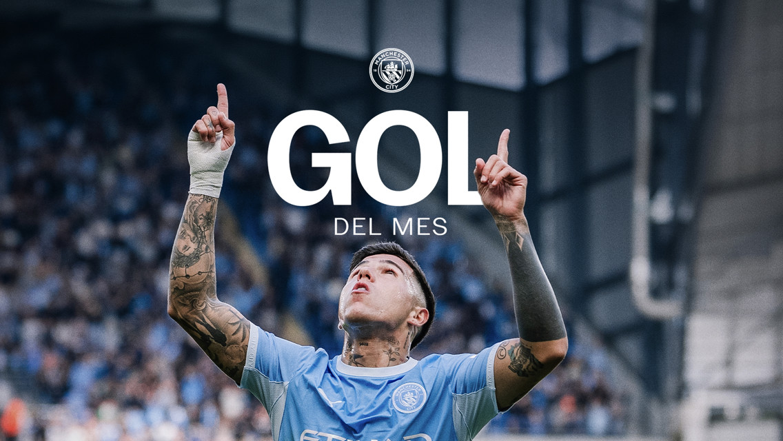 A football player in a light blue Manchester City jersey celebrates by pointing towards the sky. The text reads 'GOL DEL MES' with the Manchester City logo above it.
