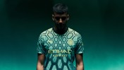 Person wearing Manchester City football jersey with hexagonal pattern, Puma logo, and Etihad Airways sponsor.
