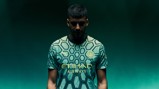 Person wearing Manchester City football jersey with hexagonal pattern, Puma logo, and Etihad Airways sponsor.