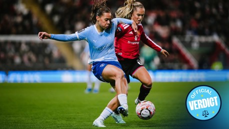 Two women soccer players from Manchester City and Manchester United in action during a match.