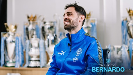 A person in a blue Manchester City tracksuit sits with multiple silver trophies in the background. Text reads 'THANK YOU BERNARDO 2017-2026'.