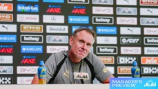 A man at a press conference with an Asahi sign, sitting in front of a backdrop featuring logos like Barclays and Betway. Two Lucozade bottles are on the table labeled 'Manager's Preview.'