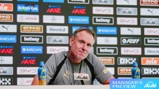 A man at a press conference with an Asahi sign, sitting in front of a backdrop featuring logos like Barclays and Betway. Two Lucozade bottles are on the table labeled 'Manager's Preview.'