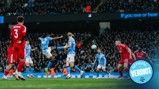 Players from Manchester City and another team in red compete for the ball during a match. The focus is on a Manchester City player in light blue attempting a shot or pass.