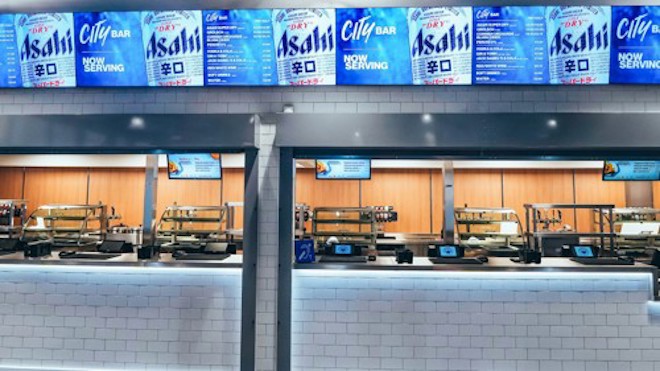 Image shows a pool bar with Asahi Super Dry beer advertisements displayed above. The counter is equipped with trays and self-service screens.