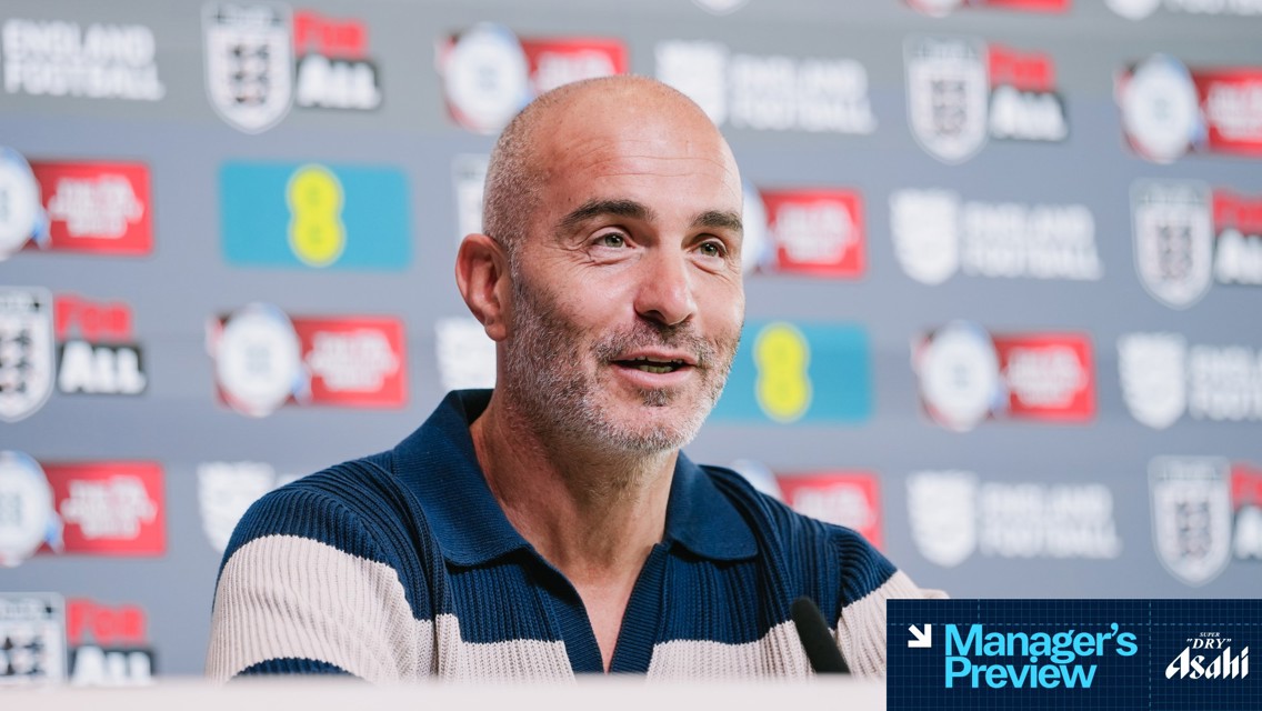 A man, likely a manager, speaking at a press conference with an England Football backdrop and various sponsors logos.