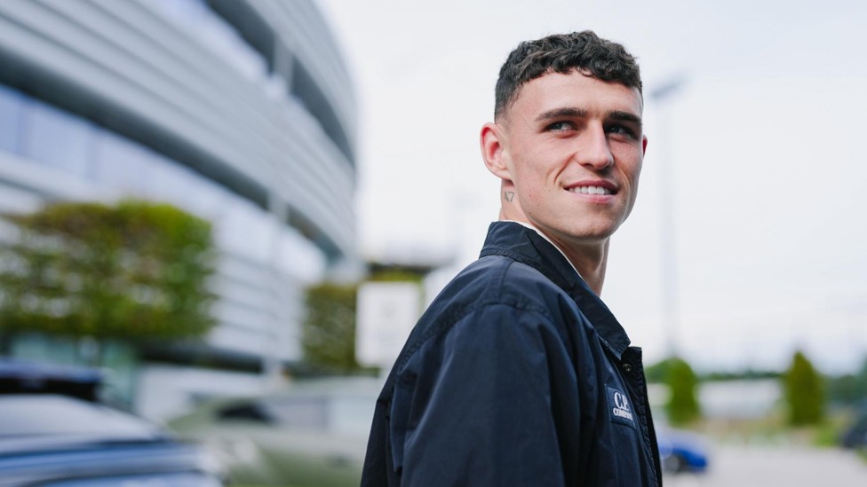 HIGH FLIER: Phil Foden shares a smile as the City squad prepare to head to Manchester Airport.