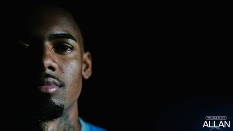 A person's face is partially illuminated on one side against a dark background with 'Welcome to City' and 'Allan' text in the corner.