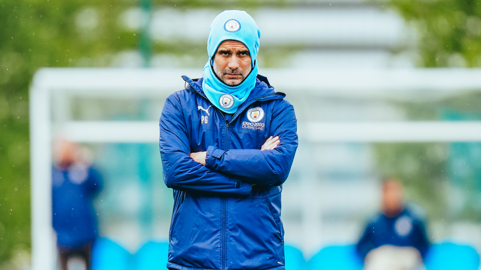 WRAPPED UP : Pep stays protected from the elements as he watches on