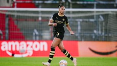 A female soccer player in a black Manchester City uniform on the field during a match.