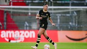 A female soccer player in a black Manchester City uniform on the field during a match.