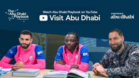 Three individuals in Manchester City attire are sitting at a table, promoting the Abu Dhabi Playbook on YouTube by Visit Abu Dhabi.