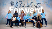 Group of individuals in Manchester City attire in front of 'Send it Forward' text on a speckled blue background.