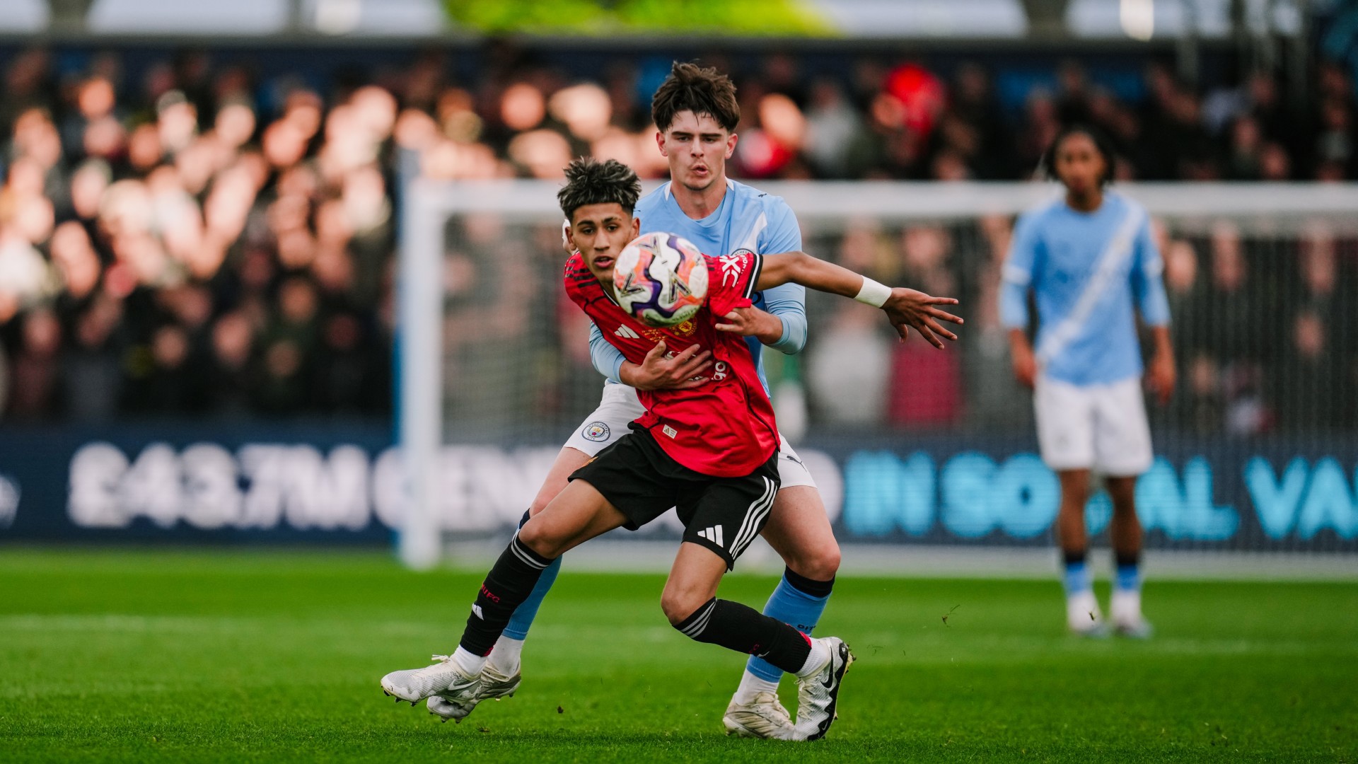 IN THE THICK OF IT: Harrison Miles puts the squeeze on United.
