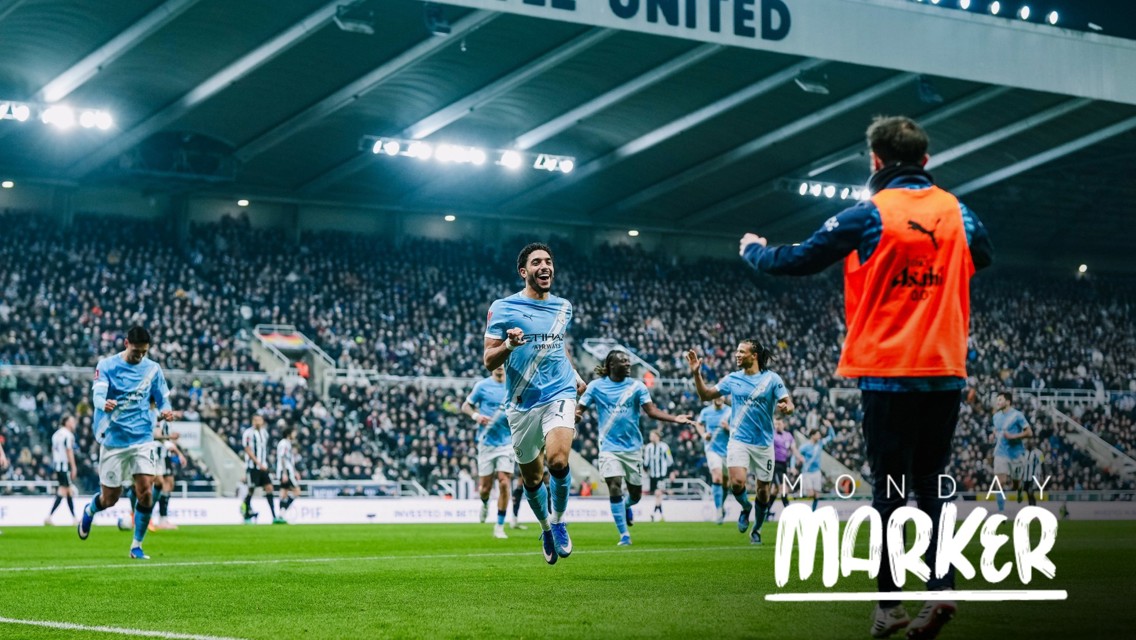 Football players in blue jerseys celebrating on a pitch, with a large crowd in the background and 'Monday Marker' text on the image.