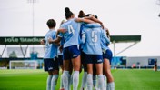 A group of soccer players in light blue jerseys huddling on the field at Joie Stadium with 'Revolut' and other text on their shirts.