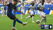 Football players in action during a World Cup match, one player kicking the ball surrounded by others, including those from opposing team.