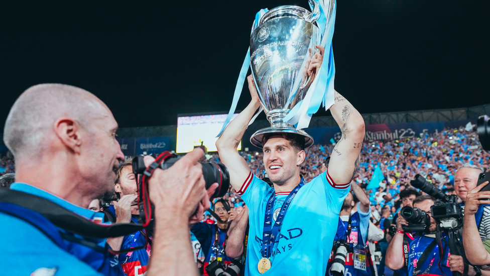 NICE HAT : John Stones uses the trophy to keep his head warm