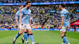 Manchester City players celebrating a goal in a football match at a stadium.