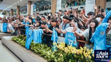 Fans at an event for Manchester City's Asia Tour '26, displaying enthusiasm and holding up team shirts while taking pictures or recording.