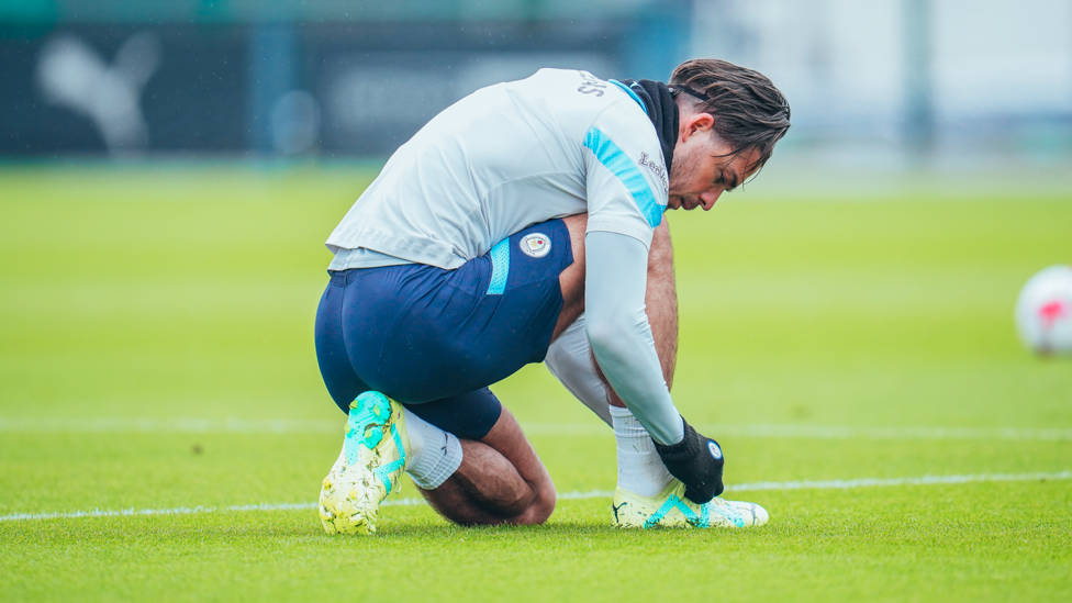 ALL TIED UP : Jack Grealish fixes his laces before continuing to train