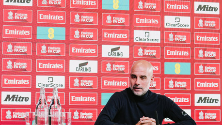 A football manager sits at a press conference for the Emirates FA Cup.