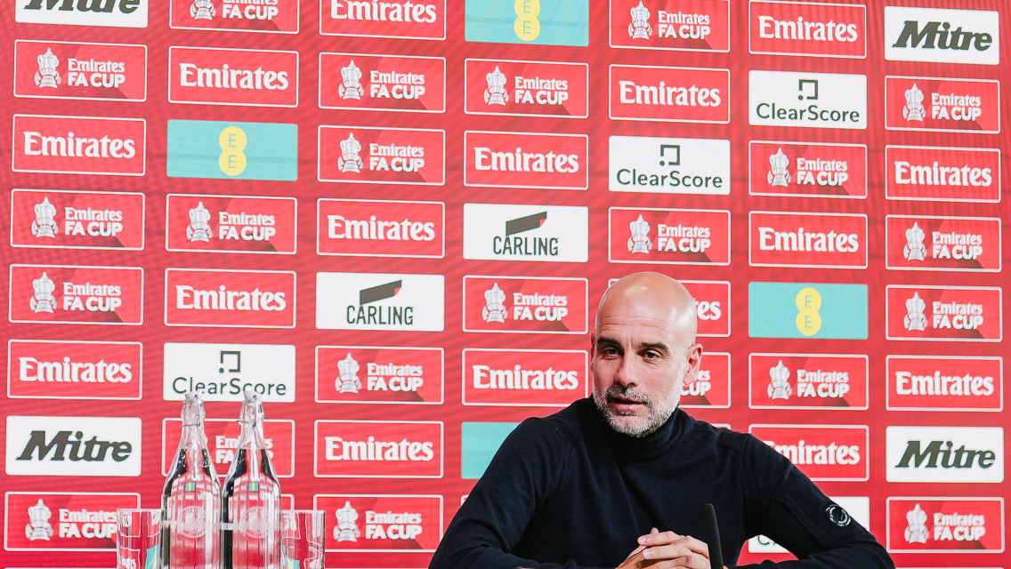 A football manager sits at a press conference for the Emirates FA Cup.