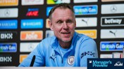 A person in a Manchester City jacket at a press conference with sponsor logos in the background. A sign at the bottom reads 'Manager's Preview' by Asahi Super Dry.