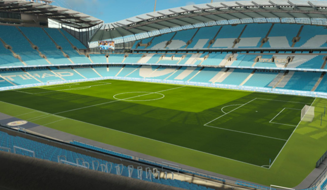 Empty Etihad Stadium with blue seats and green pitch, Manchester City branding visible.