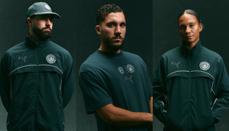 Individuals wearing Manchester City-branded Puma tracksuits and T-shirts in a dark color, featuring the club's crest and Puma logo.