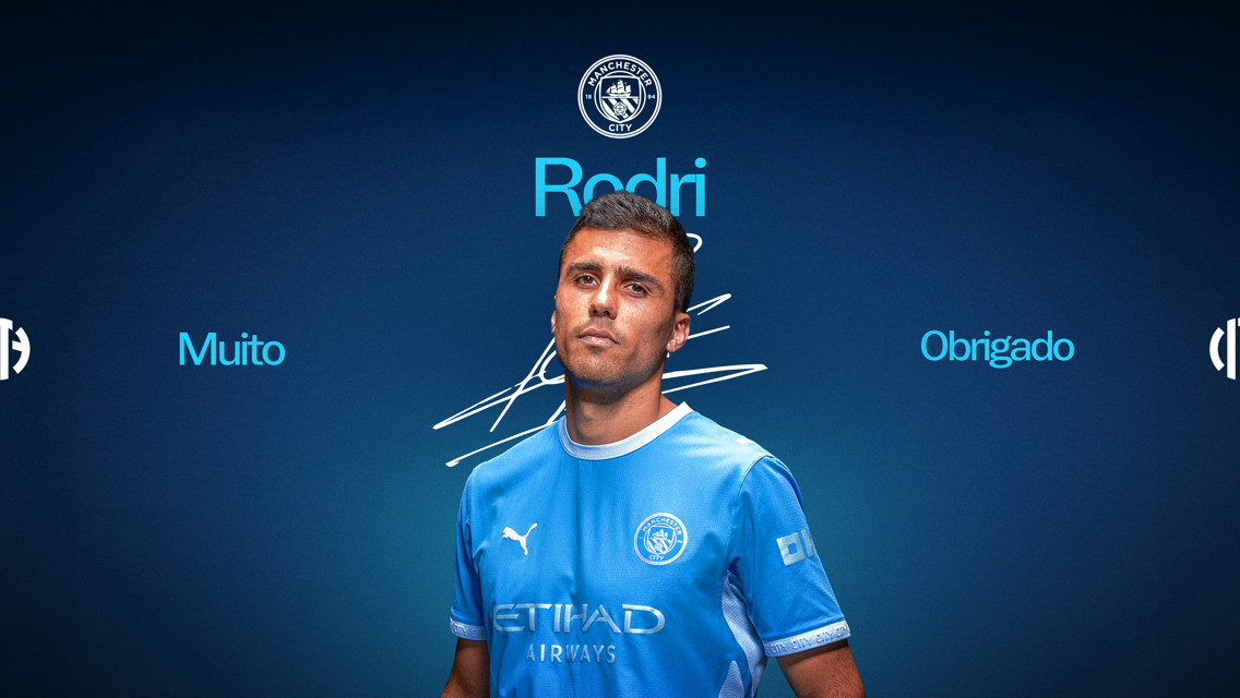 A Manchester City player wearing the team's blue kit with 'Muito Obrigado' and 'Rodri' text. Manchester City logo at the top.